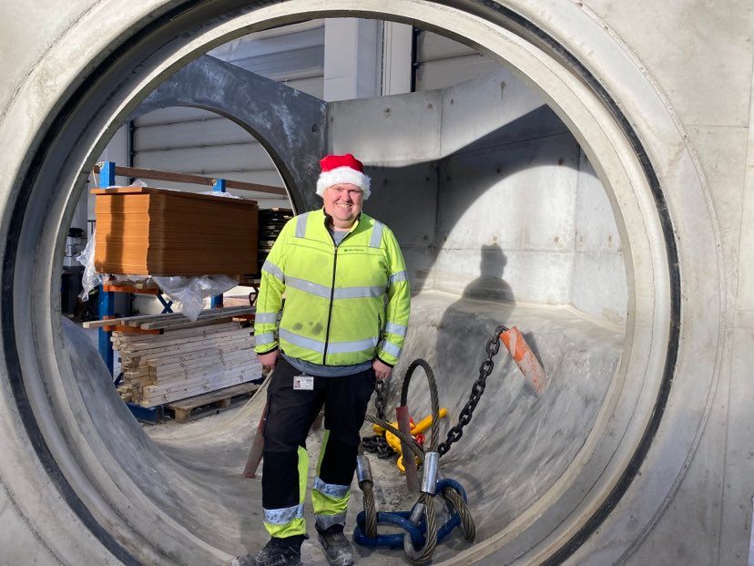 Oddgeir, med nisselue på, stående inni en stor spesialprodusert kum